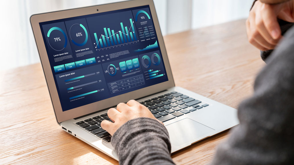 Operador en sala de control industrial verificando sistema de monitorización meteorológica con múltiples pantallas